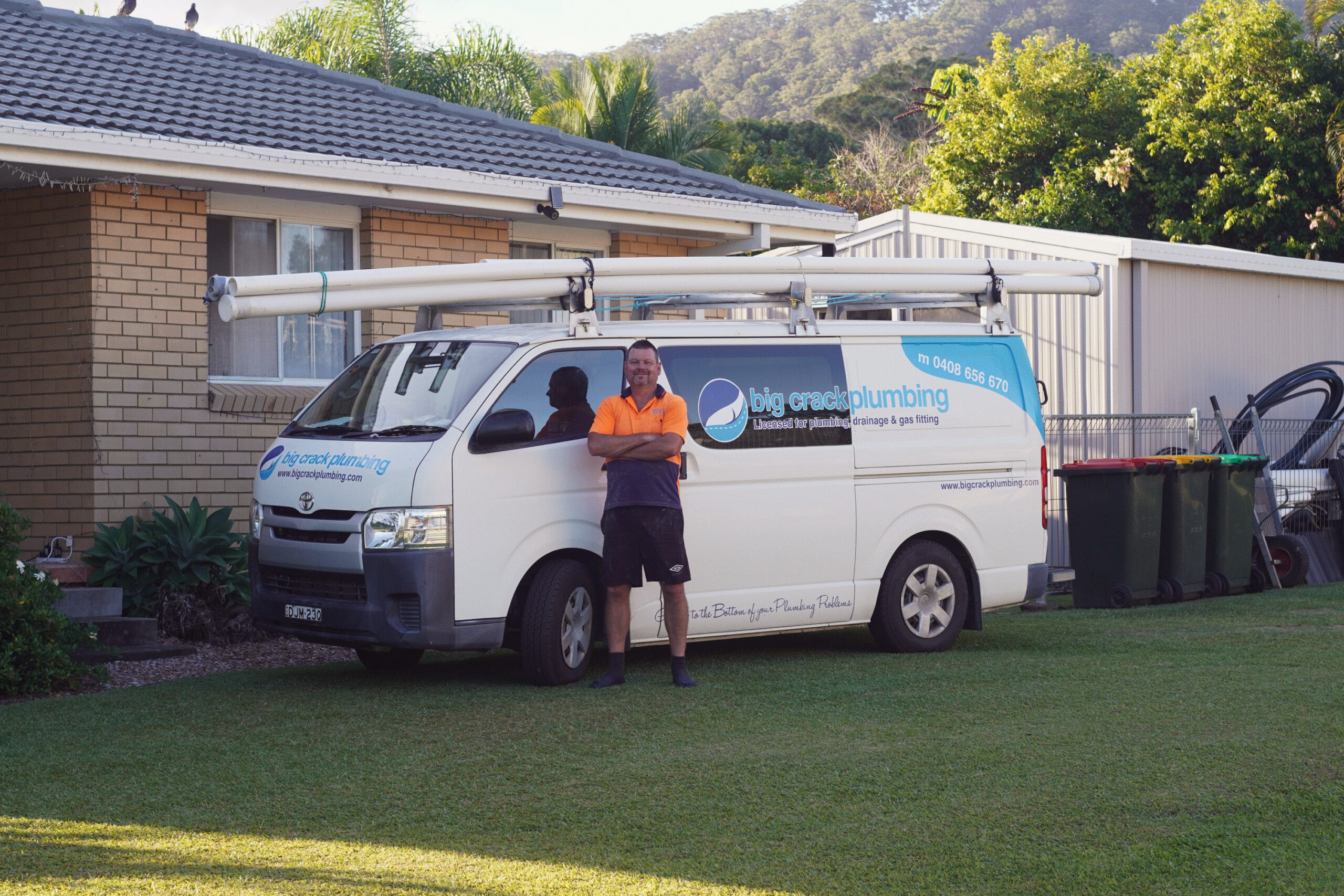 Andrew standing in front of the Big Crack Plumbing van
